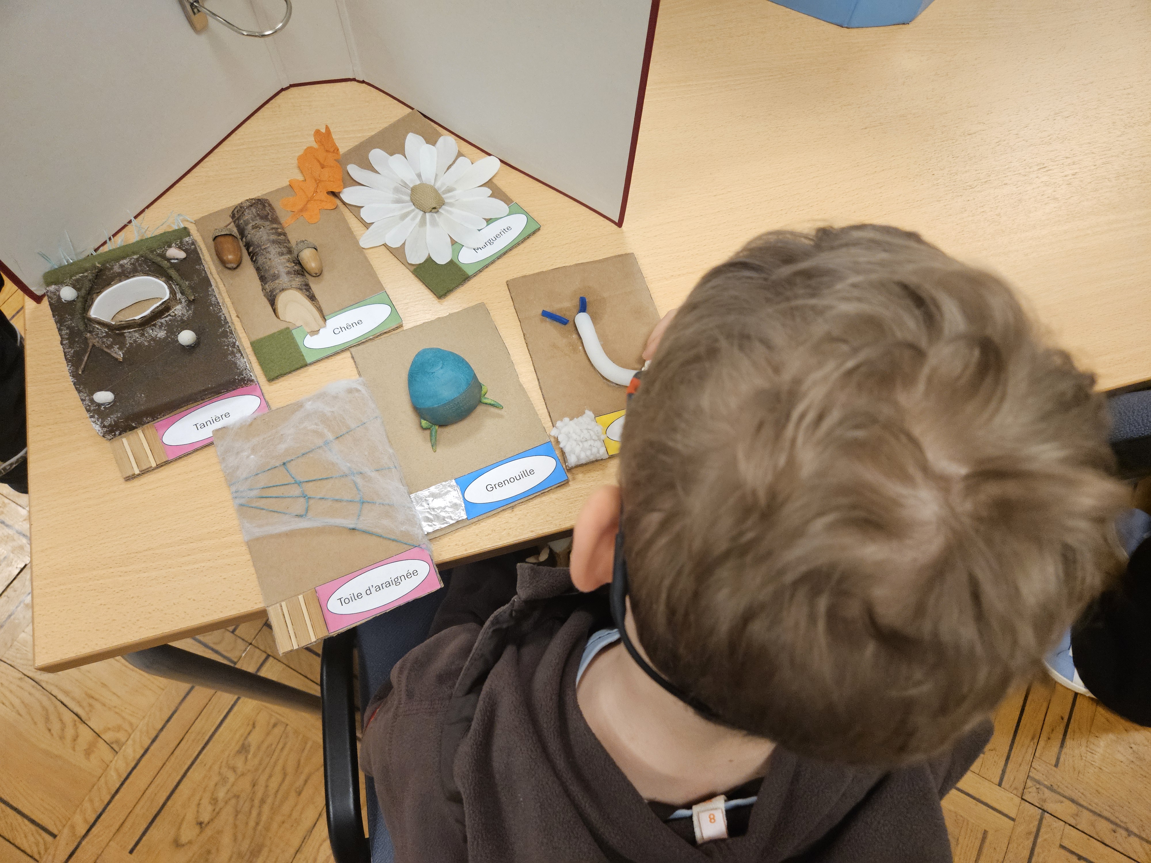 un enfant touche les cartes d'un jeu multisnesoriel créé par les étudiants 